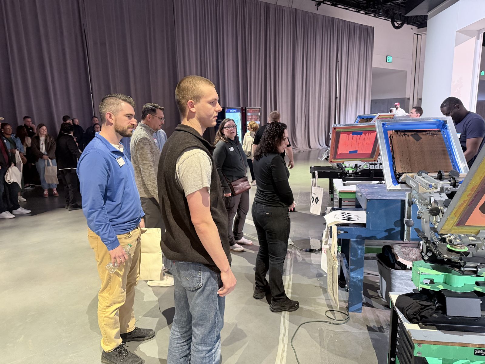 Guests lined up watching live print stations run at an evening event